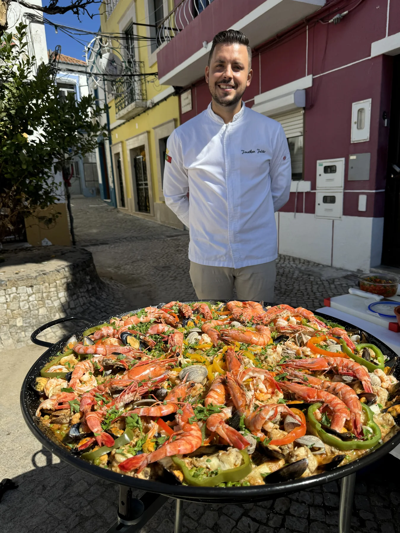 Chef Jonathan junto a uma paella preparada para um evento